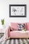 Floral pillows and blanket on pink couch in living room interior