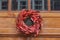 Floral red outdoor Christmas wreath hanging at entrance door