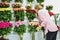 Floral refrigerator in the store. showcase with vases of roses. Florist at work