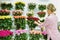 Floral refrigerator in the store. showcase with vases of roses. Florist at work