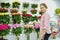 Floral refrigerator in the store. showcase with vases of roses. Florist at work