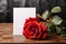 Floral simplicity Red rose with white paper on rustic tabletop