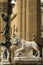 Florence, Italy - 23 April, 2018: a lion statue with the Perseus with the Head of Medusa statue behind it