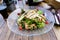 FLORENCE, ITALY - Jul 09, 2020: Chicken Greek Salad in a transparent ornate plate, Florence, Italy
