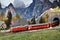 Florence, ITALY- March 2022: Model railway with the Swiss Bernina express train in a mountain ambientation with characters