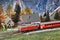 Florence, ITALY- March 2022: Model railway with the Swiss Bernina express train in a mountain ambientation with characters
