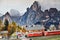 Florence, ITALY- March 2022: Model railway with the Swiss Bernina express train in a mountain ambientation with characters