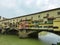 Florence - Scenic view of historic medieval Ponte Vecchio bridge with shops spanning the Arno River, Firenze