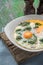 Florentine eggs with pureed spinach on the wooden table vertical