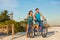 Florida beach vacation couple biking sport rental bikes recreational activity happy watching sunset on Sanibel Island by