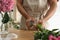 Florist cutting flower stems at table