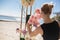 Florist girl decorates wedding arch with fresh flowers on the sandy shore of the lake. Wedding florist decorators workflow