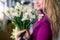 A florist girl holding a bouquet of narcissus. Floral shop