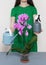 A florist girl holds a watering can and a sprayer near a purple orchid.