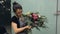 Florist hardly ties up ready beautiful bouquet with black satin ribbon