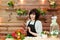 Florist holds a smartphone in his hand on the background of a wooden wall with flowers