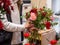 Florist makes beautiful bouquet of mixed roses and other flowers in a shop. Fresh cut flowers