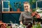 Florist makes a bouquet of multi-colored chrysanthemums. A young adult girl works with enthusiasm