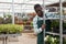 Florist pushing metal trolley with potted begonias