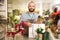 Florist putting beautiful potted plant into paper bag