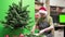 Florist in a Santa hat make beautiful Christmas decoration in fir shape