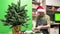 Florist in a Santa hat make beautiful Christmas decoration in fir shape