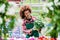 Florist smiling while holding a beautiful potted daisy flower plant