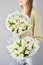 Florist woman creates beautiful two bouquet of bouquets of spring cream tulips. European floral shop concept. Handsome