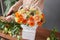 Florist woman creates flower arrangement in a wicker basket. Beautiful bouquet of mixed flowers. Floral shop concept