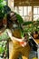 Florist woman in house garden hold pot with plant. Satisfied gardener enjoy caring of houseplants