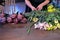 Florist woman makes bouquet of eustoma, brown peony and iris in flower shop.