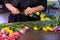 Florist woman prepares flowers to bunch cuts rose thorns in shop, closeup hands.