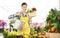 Florist woman smiling with watering can and wicker basket flowers