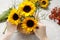 Florist at work: how to make floral arrangement with sunflowers and wild rose rosa canina twigs