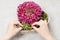 Florist at work: how to make simple floral arrangement with pink chrysanthemum flower and moss