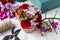 Florist at work. Woman making floral arrangement with red carnat