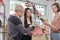 The florist workers deliver fresh floras to customer in colorful flower shop.