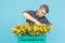 Floristics, holidays and people concept - Man gardener fixing a bouquet of tulips on blue background.