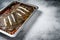 Flounder flat fish roasted in a tomato sauce in baking tray. White background. Top view. Copy space