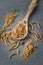 Flour of edible mealworms in wooden spoon on grey granite table