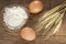 Flour, eggs and oats on wooden table