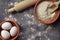 Flour, eggs and rolling pin on a wooden background. Top view. Or