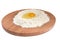 Flour and eggs on a wooden round board.