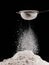 flour falling from sieve on pile