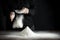 Flour on a kitchen table on a black moody background in the morning light. Woman`s hands sieving flour through a sieve.