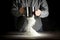 Flour on a kitchen table on a black moody background in the morning light. Woman`s hands sieving flour through a sieve.