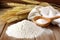 flour in a sack with wheat stalks beside it on a wooden table