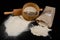 Flour sieved for homemade pastries. Accessories in home kitchen on a dark table