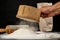 Flour sifted through an old wooden sieve. Accessories in home kitchen on a dark table