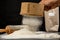 Flour sifted through an old wooden sieve. Accessories in home kitchen on a dark table